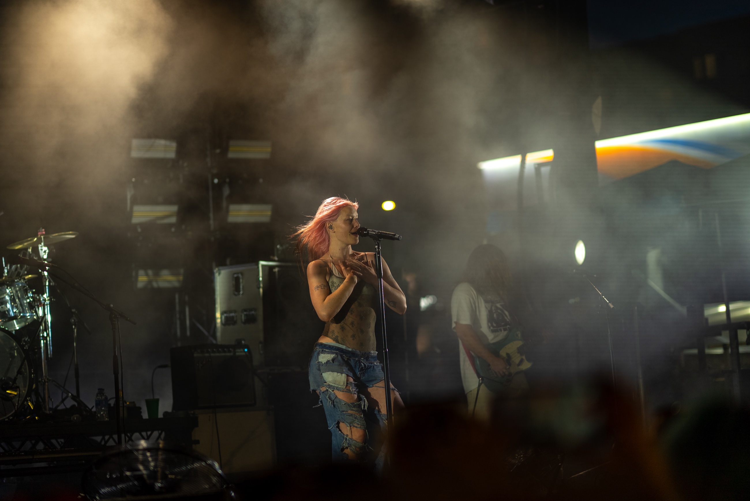 Rhian Teasdale of Wet Leg singing through stage smoke, photographed from the Capitol Hill Block Party crowd
